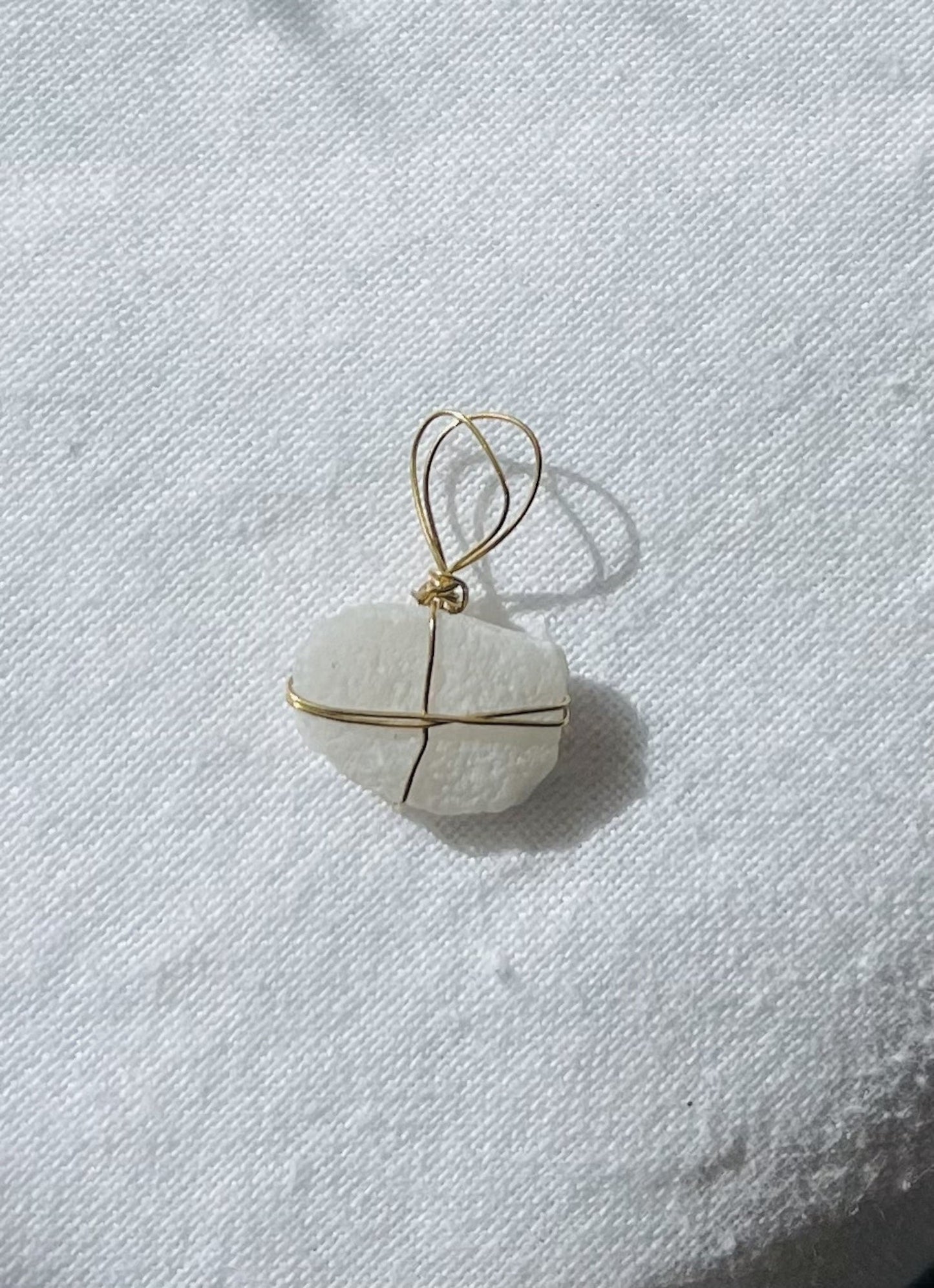 Textured white charm with delicate markings and gold-coloured tarnish-resistant wire