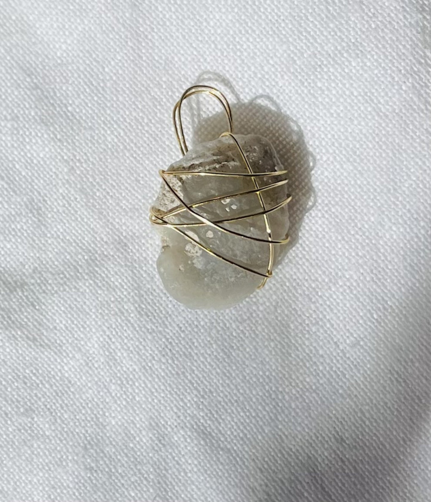 Bean-shaped alien glass pendant with smooth and textured surfaces