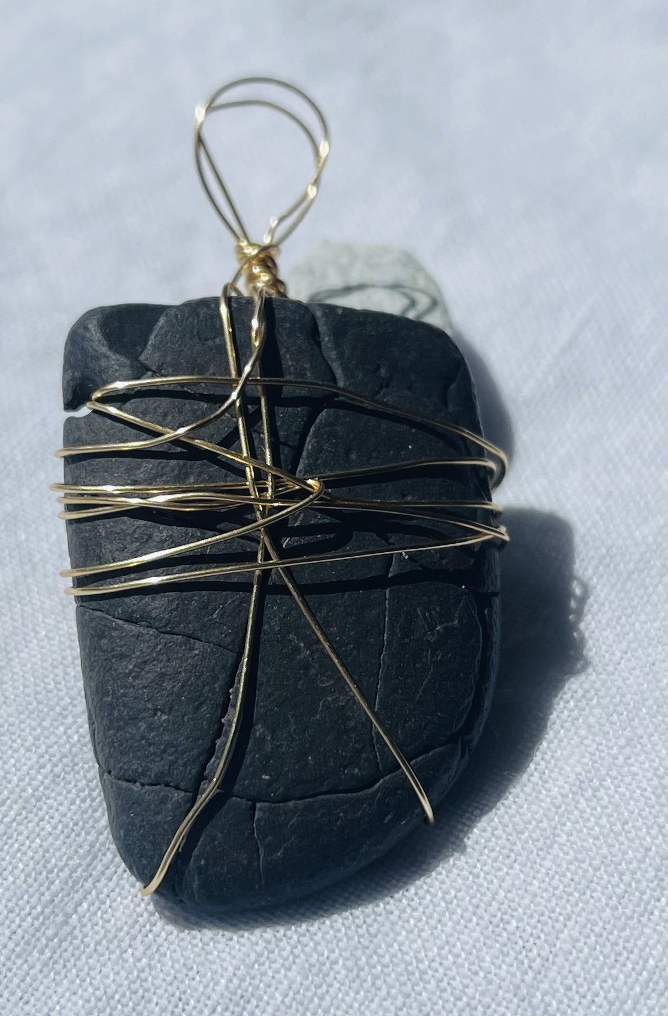 Shield-shaped pendant with intricate markings