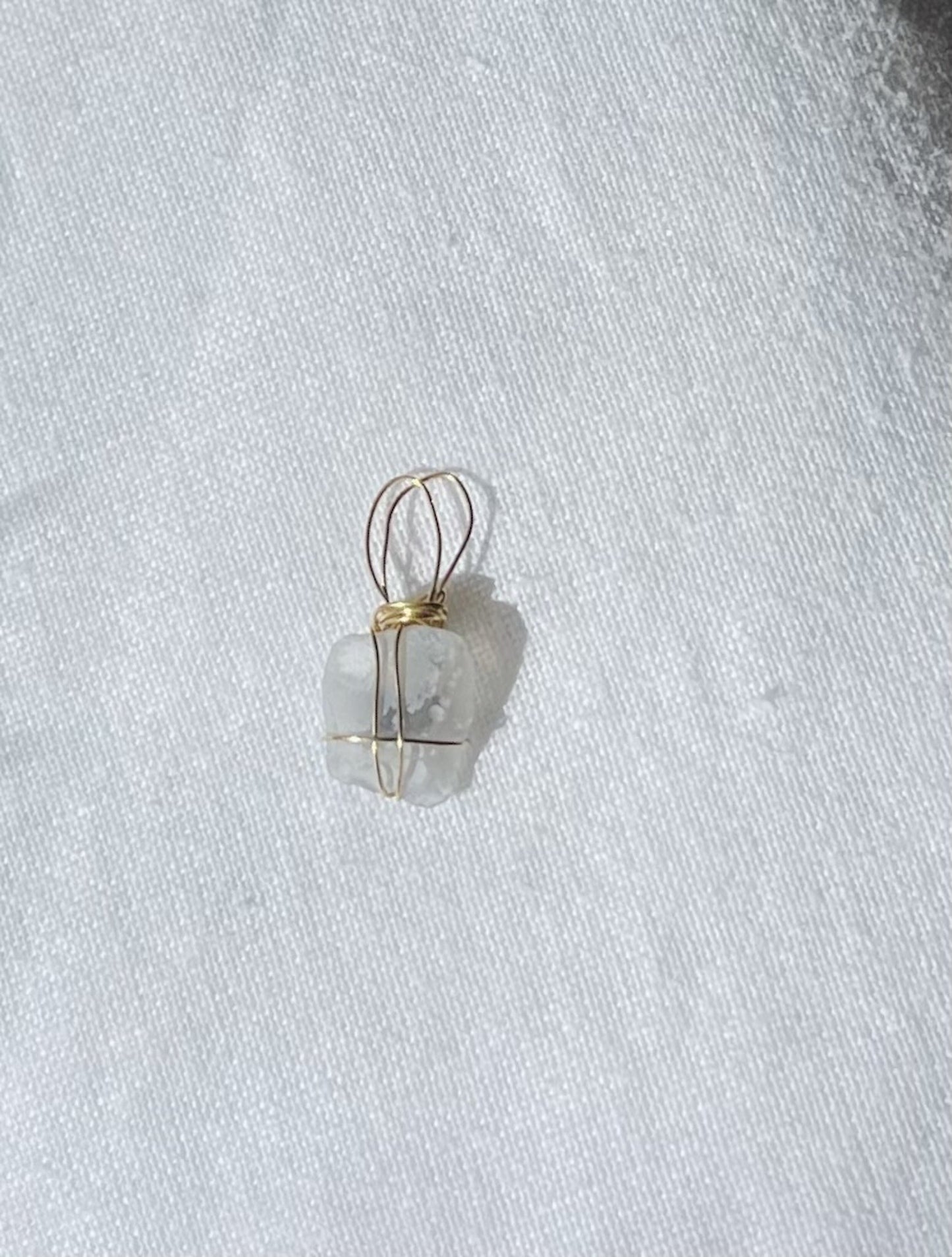Translucent charm with navy accents and crater-like patterns